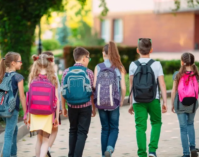 Group of children walking with backpacks outdoors