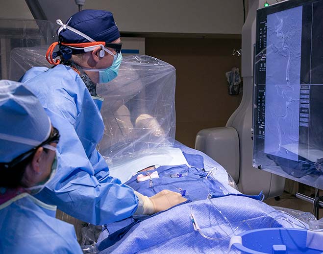 Surgical team performing procedure with imaging screen
