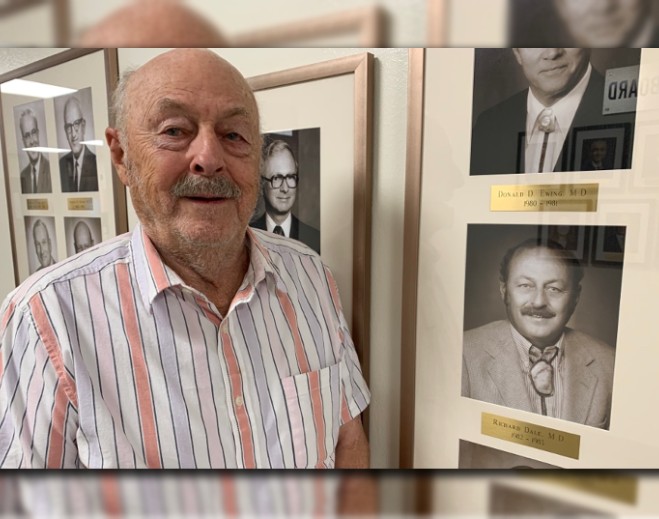 Person standing near framed photo display