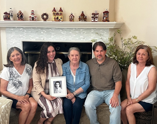 Family group photo holding framed portrait