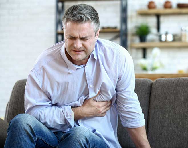 Person holding chest in visible discomfort