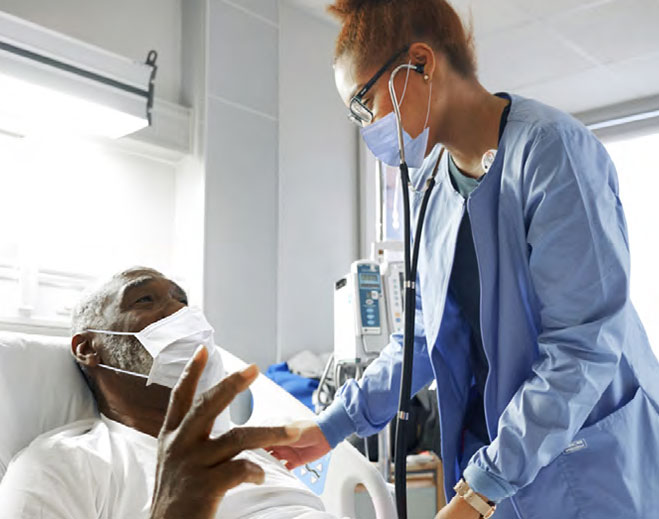 Nurse checking patient in hospital bed