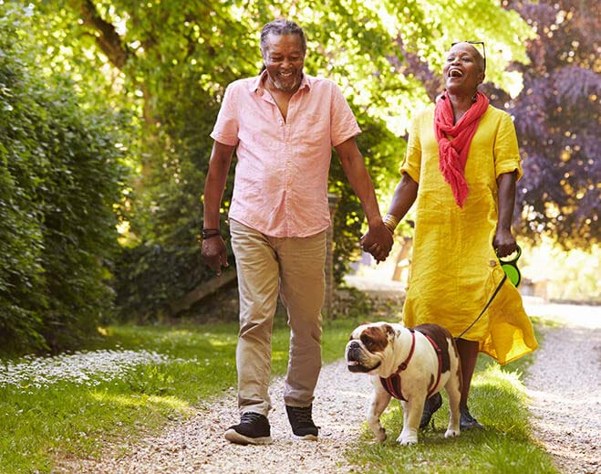 Couple walking dog on scenic path