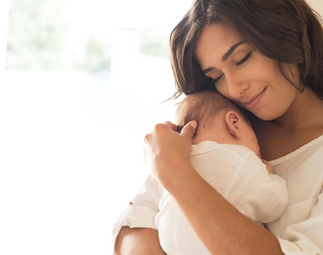 Caregiver holding infant against shoulder
